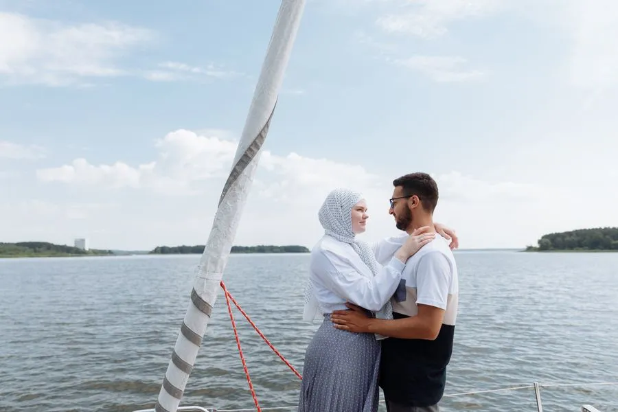Couple embracing on the deck of a boat by the water
