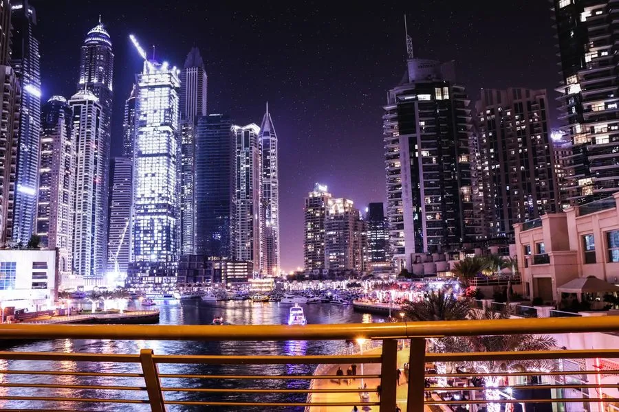 Illuminated high-rise towers around the water at Dubai Marina at night