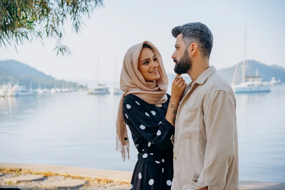 Smiling couple standing together beside a marina
