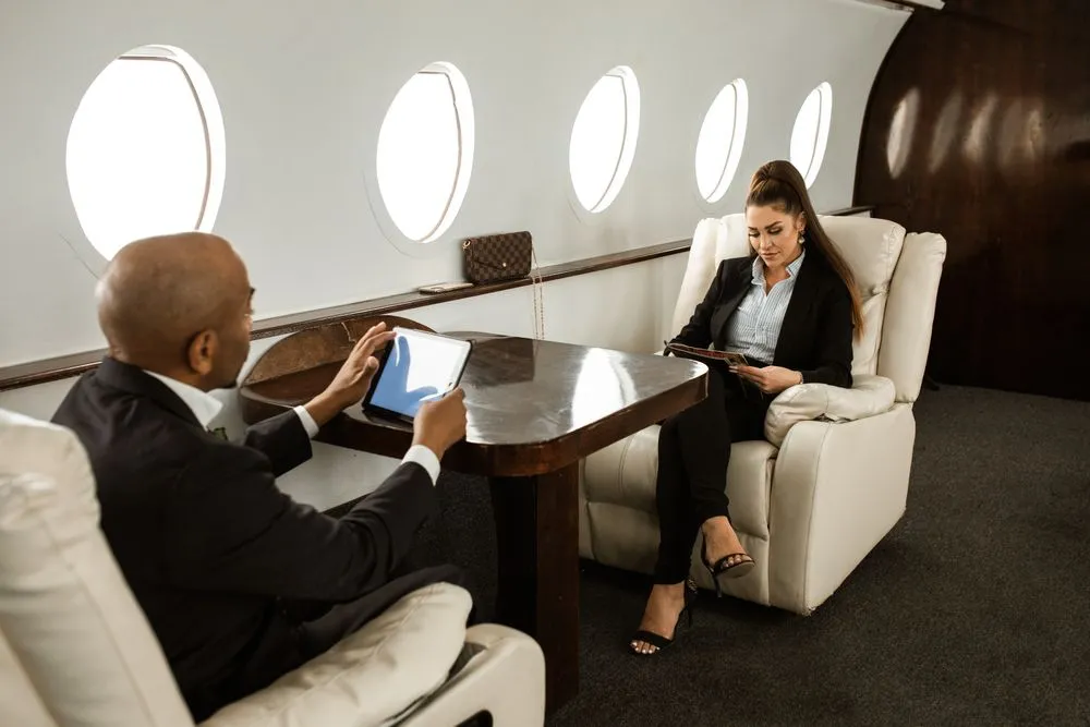 Two executives working together in the cabin of a private jet