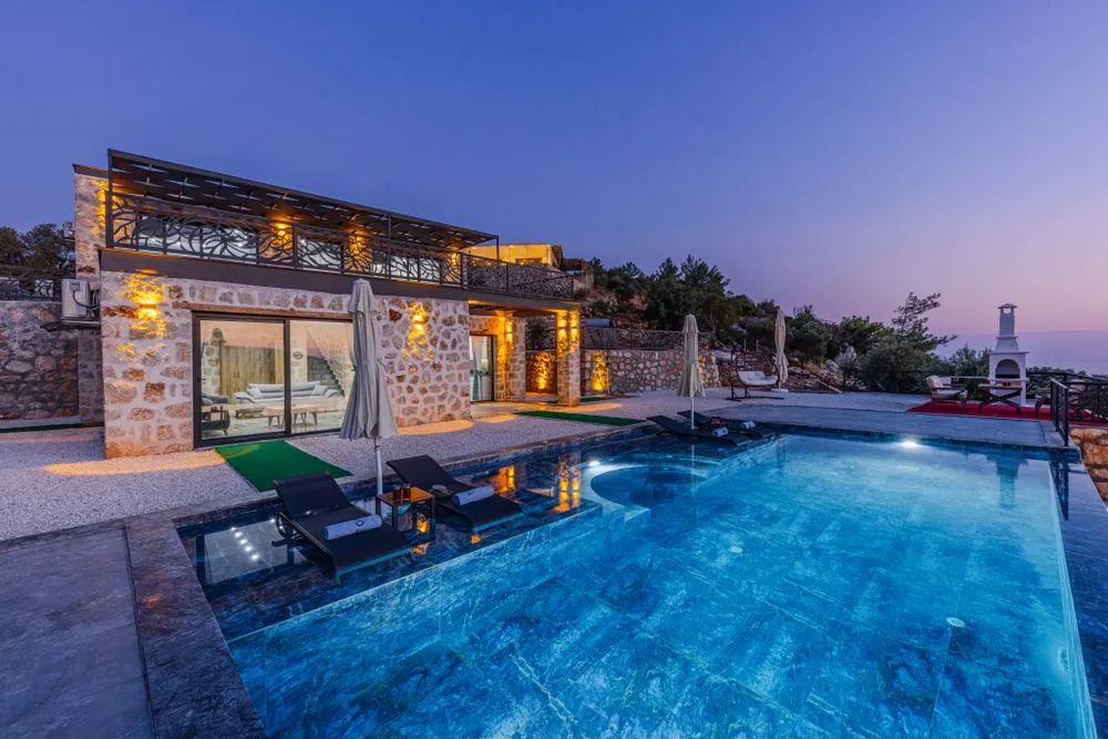 Private villa with an illuminated pool at dusk