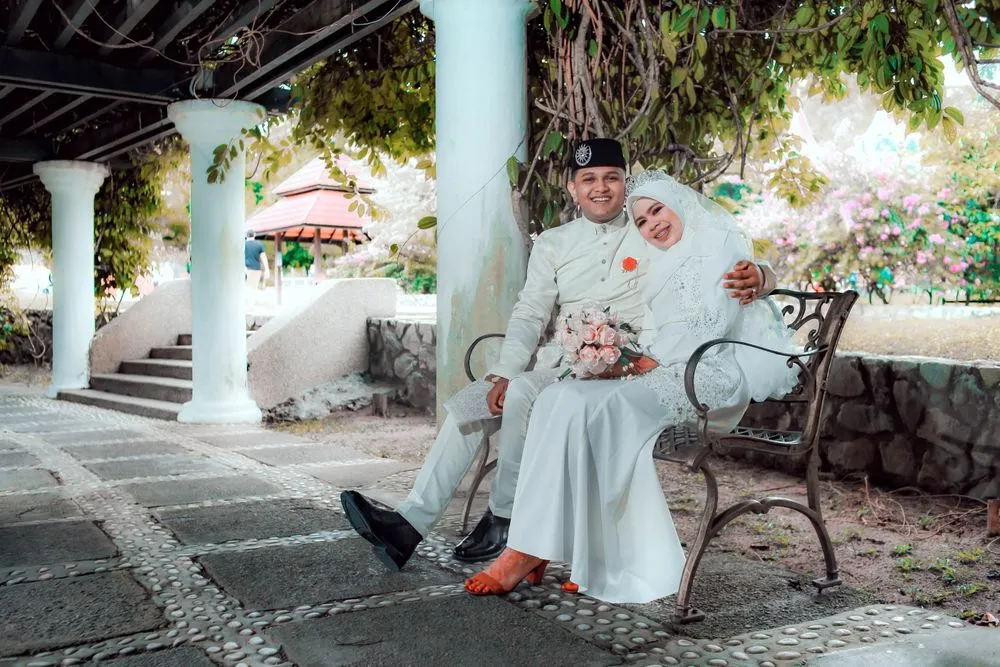 Bride and groom sitting together in a garden